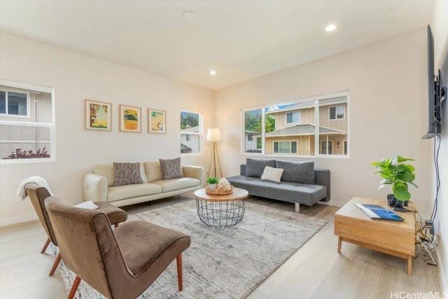 living room with baseboards, light wood finished floors, and recessed lighting