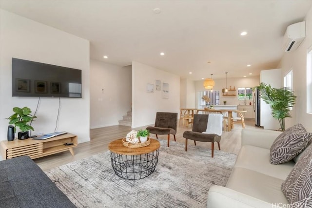 living room featuring stairs, an AC wall unit, wood finished floors, and recessed lighting