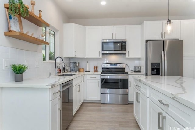 kitchen with open shelves, white cabinets, stainless steel appliances, and a sink