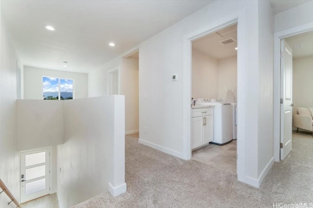 hallway with recessed lighting, light carpet, visible vents, baseboards, and washer and clothes dryer