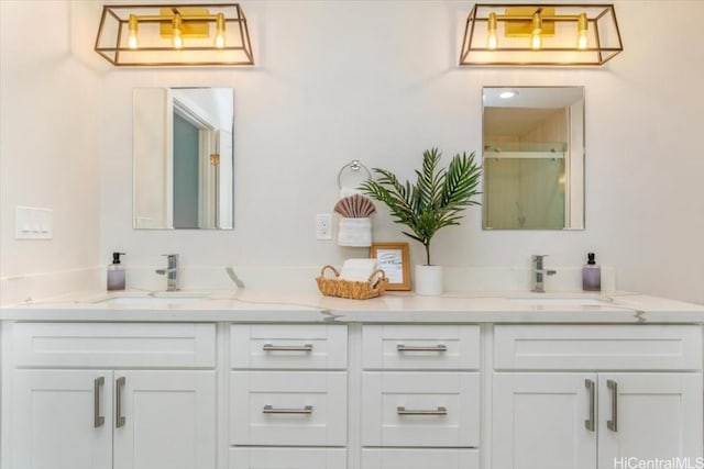 bathroom with double vanity, a shower stall, and a sink