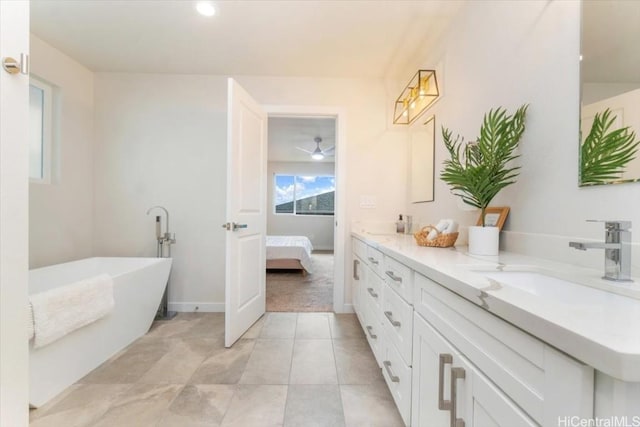 ensuite bathroom with double vanity, connected bathroom, a soaking tub, tile patterned floors, and a sink