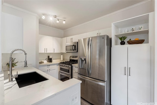 kitchen with white cabinetry, stainless steel appliances, crown molding, and a sink