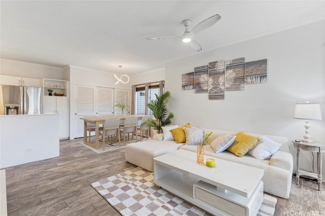 living room featuring ceiling fan, wood finished floors, and ornamental molding