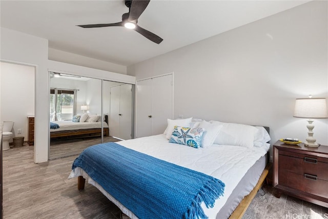 bedroom featuring a ceiling fan, wood finished floors, and ensuite bathroom