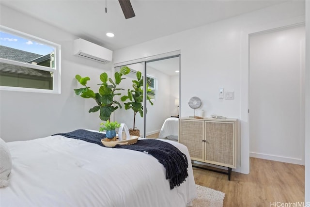 bedroom with recessed lighting, a closet, wood finished floors, a wall mounted air conditioner, and baseboards