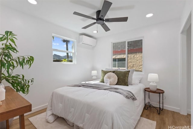 bedroom featuring baseboards, an AC wall unit, light wood finished floors, and recessed lighting