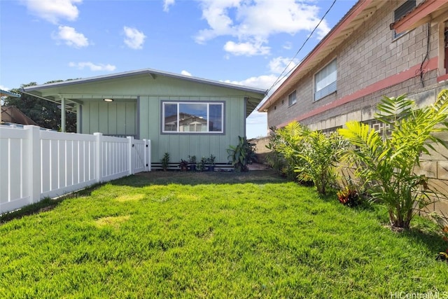 rear view of house with a lawn and fence