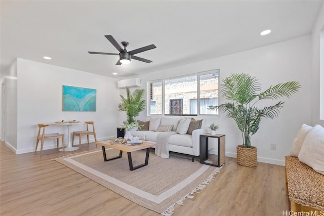 living room with ceiling fan, light wood-style flooring, recessed lighting, baseboards, and a wall mounted air conditioner