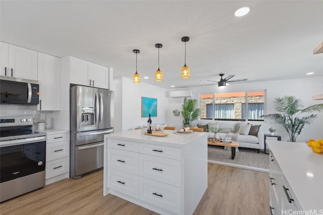 kitchen featuring light wood-style flooring, stainless steel appliances, light countertops, and a wall mounted AC