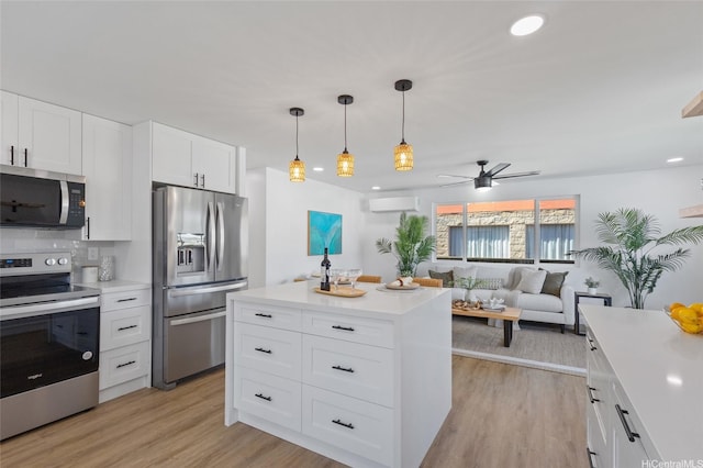 kitchen with light countertops, appliances with stainless steel finishes, a wall mounted air conditioner, and ceiling fan