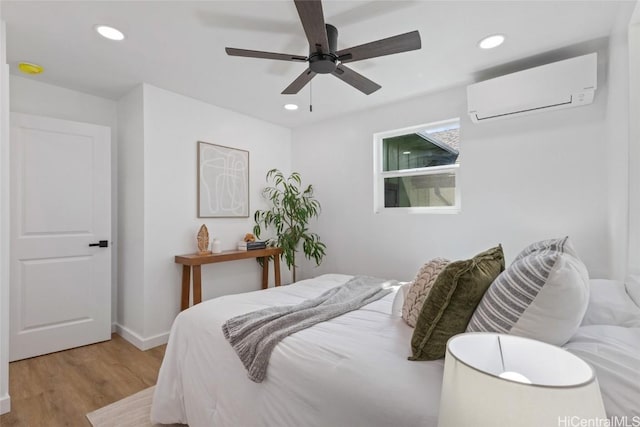 bedroom with recessed lighting, a ceiling fan, wood finished floors, and a wall mounted air conditioner