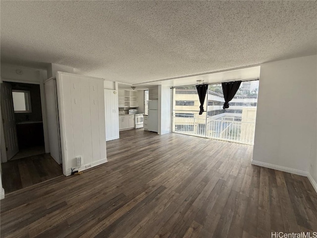 unfurnished living room featuring dark wood-style floors, a textured ceiling, and baseboards