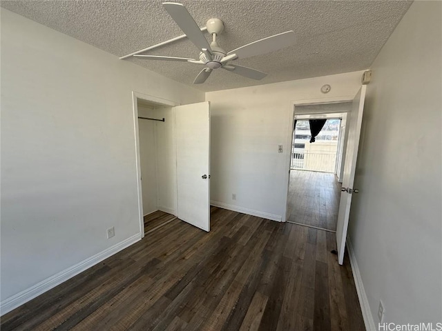 unfurnished bedroom featuring dark wood-style floors, a ceiling fan, baseboards, and a textured ceiling