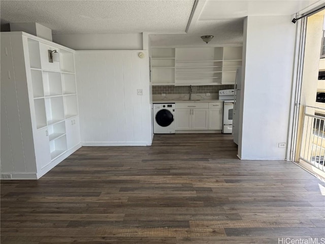 kitchen featuring dark wood finished floors, washer / clothes dryer, white electric range, open shelves, and a sink