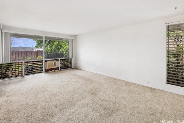 carpeted spare room featuring plenty of natural light and cooling unit