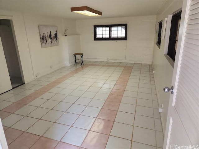 spare room featuring baseboards and light tile patterned flooring