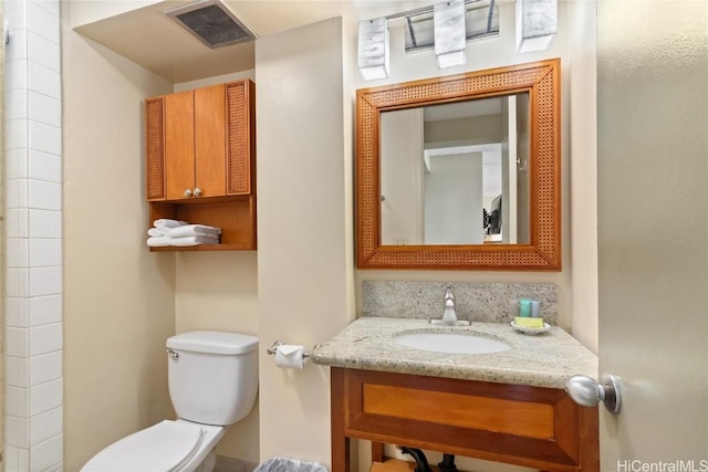 bathroom with visible vents, vanity, and toilet