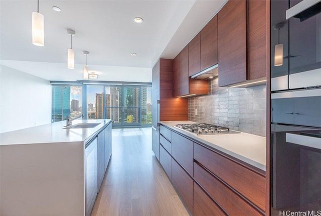 kitchen featuring tasteful backsplash, modern cabinets, stainless steel gas cooktop, and a sink