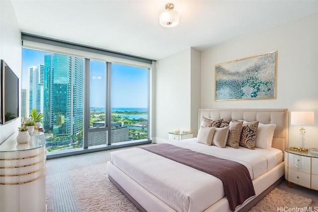 carpeted bedroom with access to exterior, floor to ceiling windows, and a water view