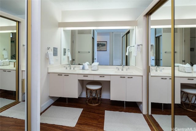 bathroom with double vanity, wood finished floors, and a sink