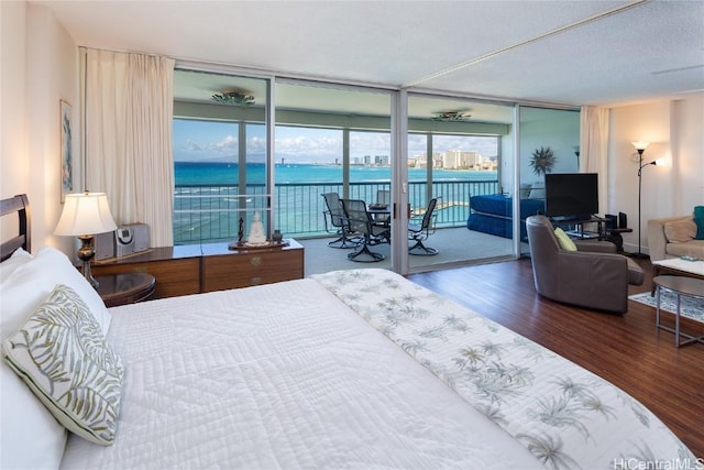 bedroom featuring access to outside, wood finished floors, and floor to ceiling windows