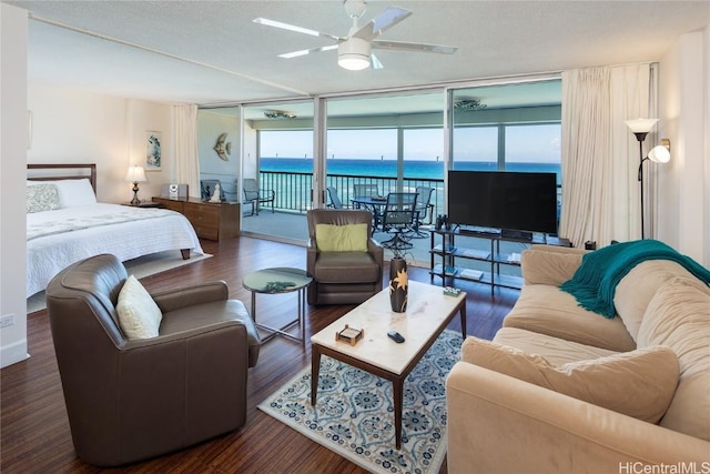 bedroom with access to exterior, floor to ceiling windows, ceiling fan, a textured ceiling, and wood finished floors