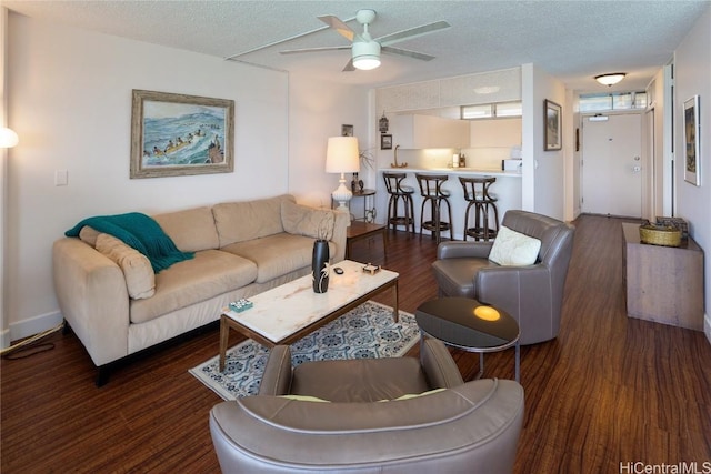 living area with a textured ceiling, wood finished floors, and a ceiling fan