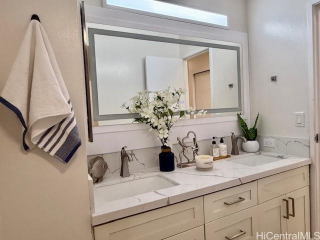 full bath with plenty of natural light, a sink, and double vanity