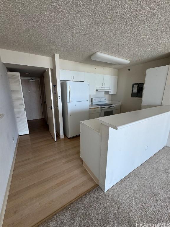 kitchen with a textured ceiling, light wood-style flooring, white appliances, white cabinets, and light countertops