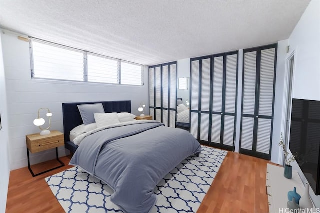 bedroom featuring light wood finished floors and a textured ceiling