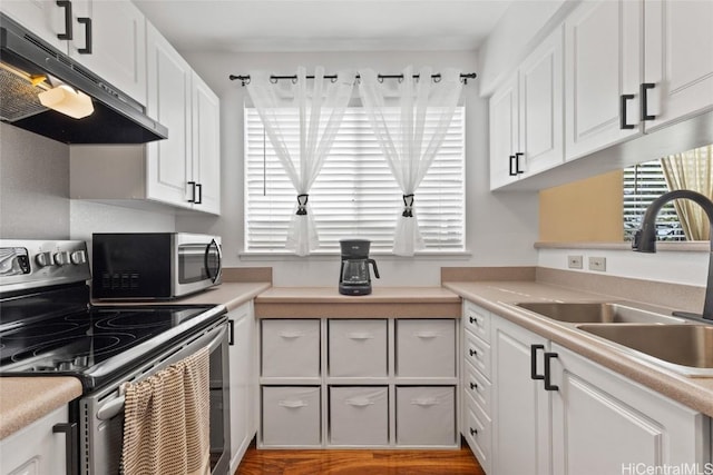 kitchen featuring under cabinet range hood, a sink, white cabinetry, light countertops, and appliances with stainless steel finishes