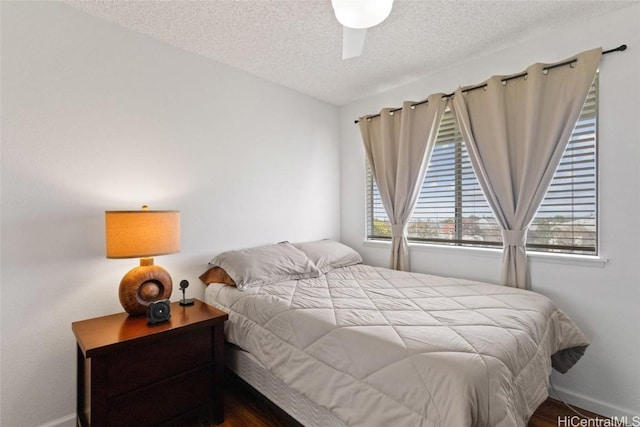 bedroom featuring a textured ceiling, a ceiling fan, and baseboards