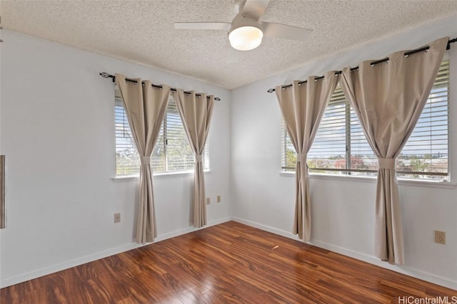 unfurnished room with ceiling fan, a textured ceiling, baseboards, and wood finished floors