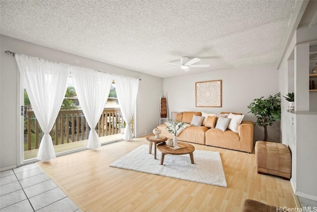 living room featuring a textured ceiling, a ceiling fan, and wood finished floors