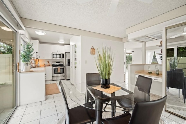 dining area with light tile patterned floors and a textured ceiling