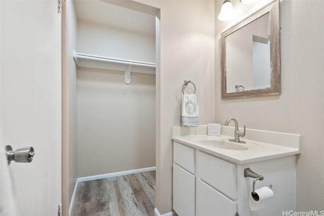 bathroom with baseboards, wood finished floors, and vanity
