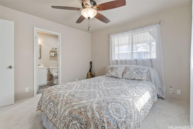 bedroom with light colored carpet, ceiling fan, and ensuite bathroom