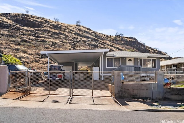 view of front of home featuring a fenced front yard, a gate, a mountain view, and a carport