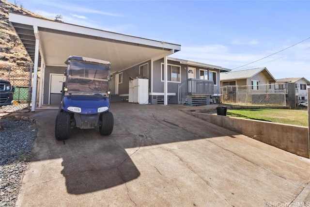 view of front of home featuring driveway, fence, a front lawn, and a carport