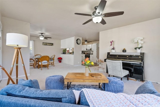 carpeted living area with a ceiling fan and baseboards