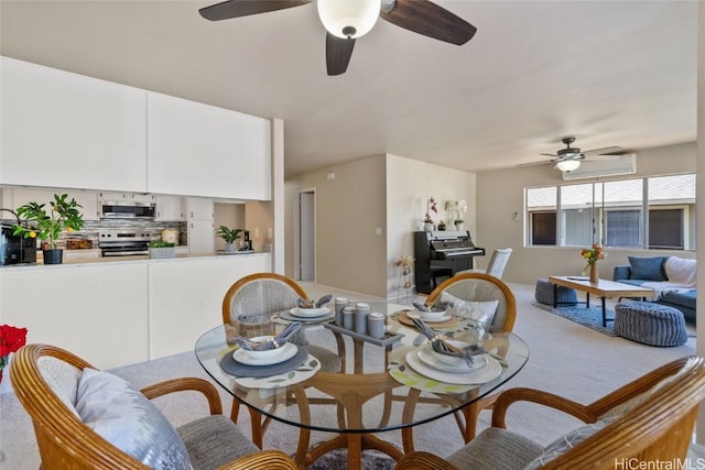 dining area featuring a wall unit AC and ceiling fan