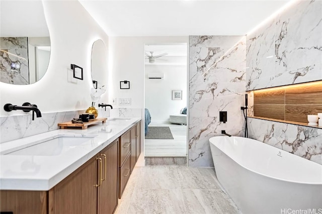 ensuite bathroom with a wall unit AC, a freestanding bath, a ceiling fan, a sink, and ensuite bath