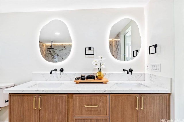 full bathroom featuring toilet, double vanity, and a sink