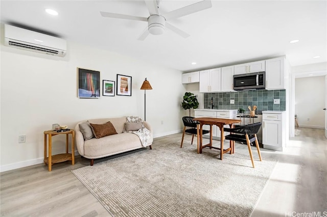 interior space featuring light wood finished floors, baseboards, an AC wall unit, and recessed lighting