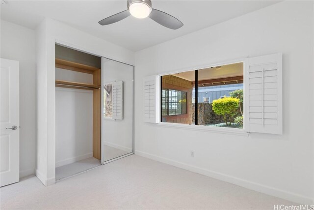unfurnished bedroom featuring carpet floors, a closet, ceiling fan, and baseboards