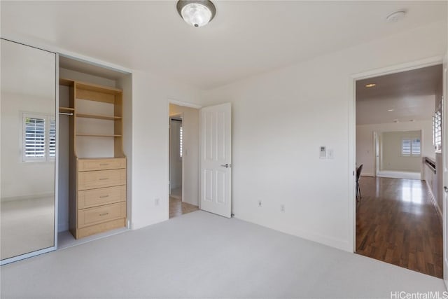 unfurnished bedroom with a closet and carpet flooring