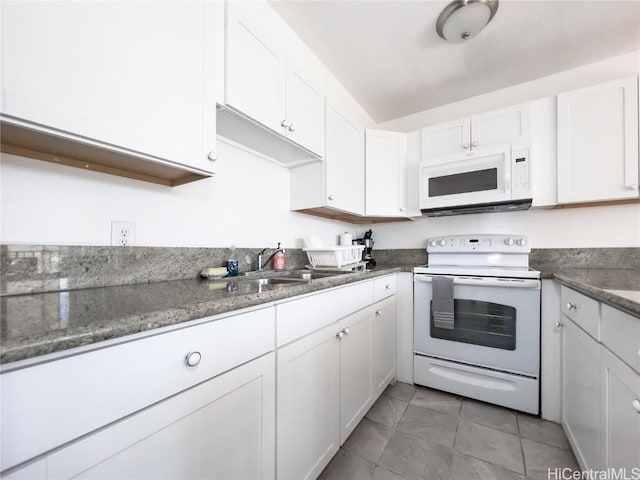 kitchen featuring white appliances, stone counters, white cabinetry, and a sink