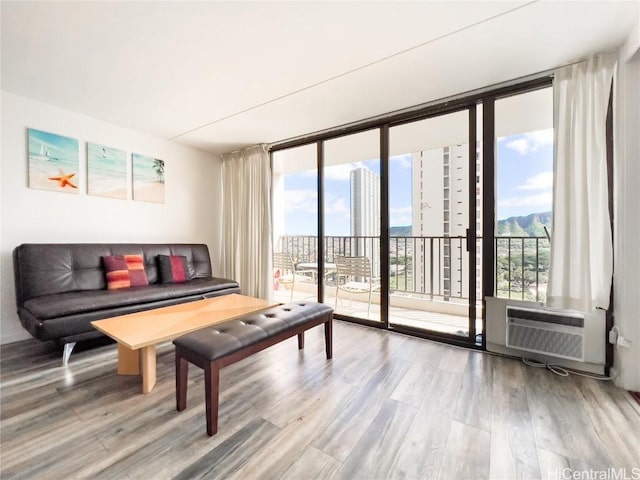 living room with expansive windows, a view of city, wood finished floors, and a wealth of natural light