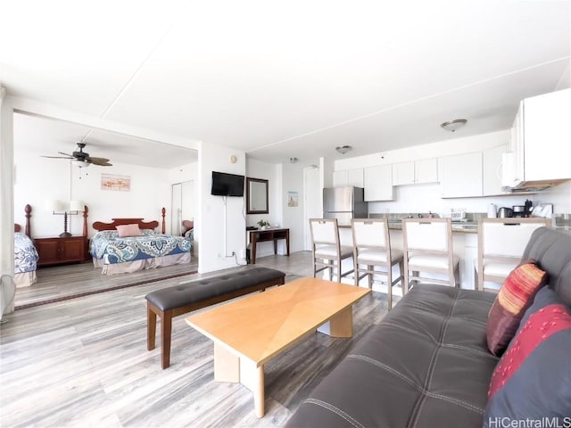 living room with light wood-style flooring and a ceiling fan